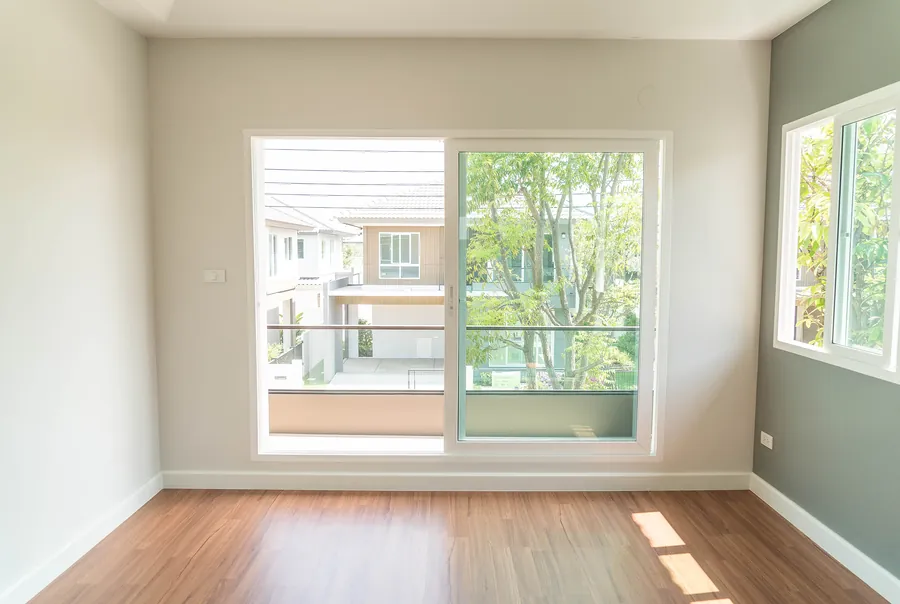Habitación con ventana corredera blanca al jardín